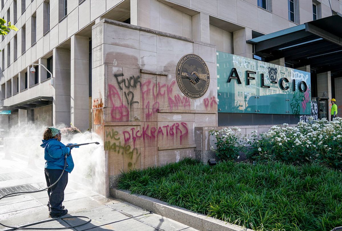 Workers clean graffiti off of an entrance sign to the AFL-CIO headquarters that was vandalized during overnight unrest, June 1, 2020 in Washington, DC (Drew Angerer/Getty Images)