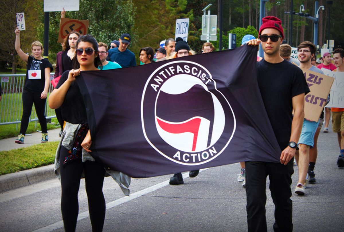 Anti-fascists carry a flag in front of protesters (Emily Molli/NurPhoto via Getty Images)