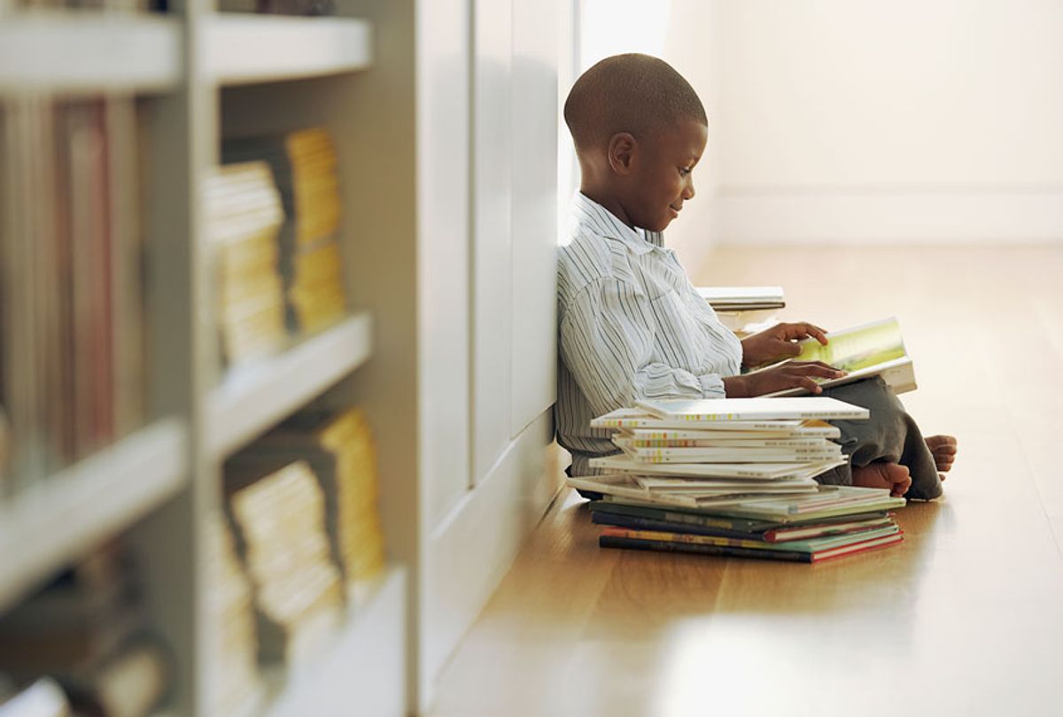 Young boy with a stack of storybooks (Getty Images)