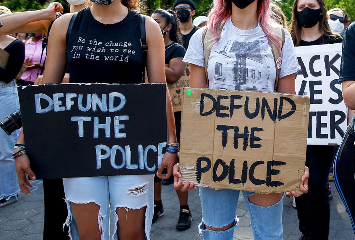 Demonstrators hold placards saying 'Defund The Police' during the protest. (John Lamparski/SOPA Images/LightRocket via Getty Images)