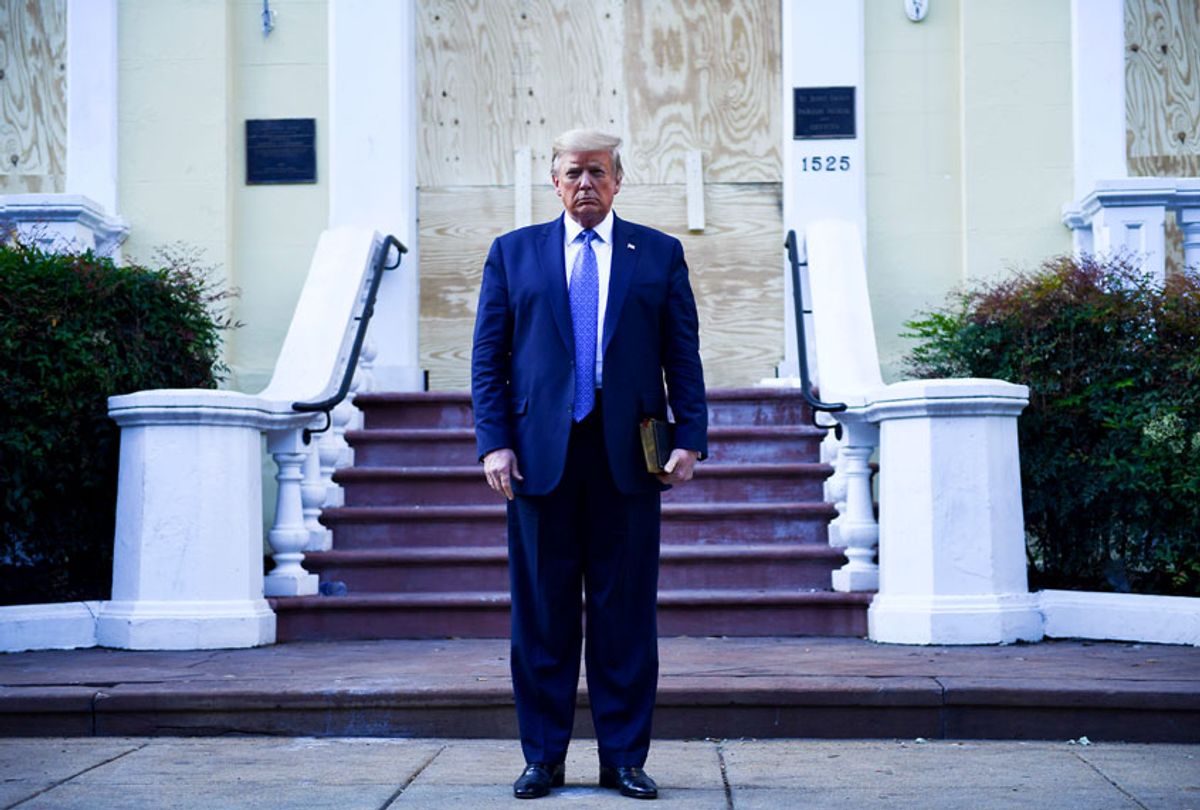 US President Donald Trump holds up a bible in front of boarded up St John's Episcopal church after walking across Lafayette Park from the White House in Washington, DC on June 1, 2020. (BRENDAN SMIALOWSKI/AFP via Getty Images)