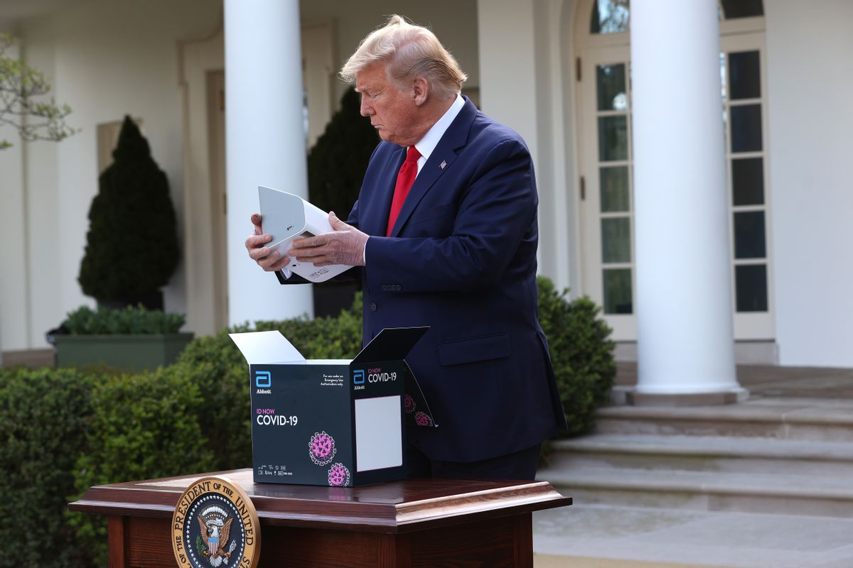 MARCH 30: U.S. President Donald Trump takes a new COVID-19 test kit developed by Abbott Labs out of its box during the daily coronavirus briefing at the Rose Garden of the White House on March 30, 2020 in Washington, DC.  (Photo by Win McNamee/Getty Images)