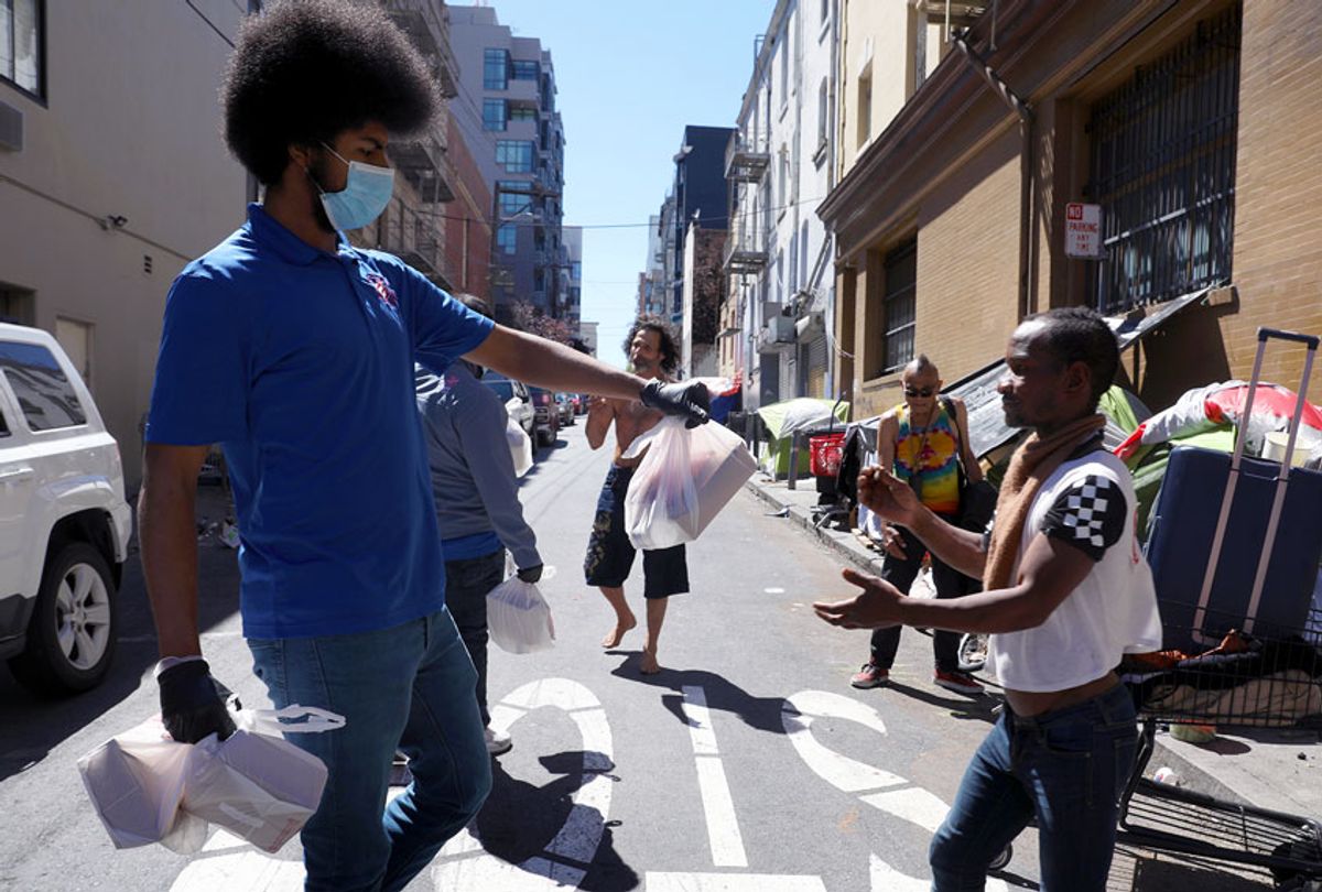 After school program and day camp lead Francisco Craig (left) hands out care packages on Willow near Polk St. in the Tenderloin on Tuesday, April 28, 2020, in San Francisco, Calif.  (Liz Hafalia/The San Francisco Chronicle via Getty Images)