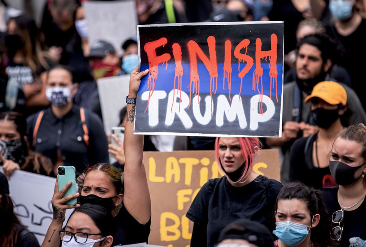 A protester holds a sign that says, "FINISH TRUMP" with the Finish in red dripping letters among the large protest crowd in Foley Square (Ira L. Black/Corbis via Getty Images)