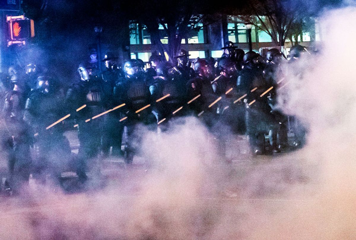 Police in riot gear stand near Centennial Olympic Park during rioting and protests in Atlanta (JOHN AMIS/AFP via Getty Images)