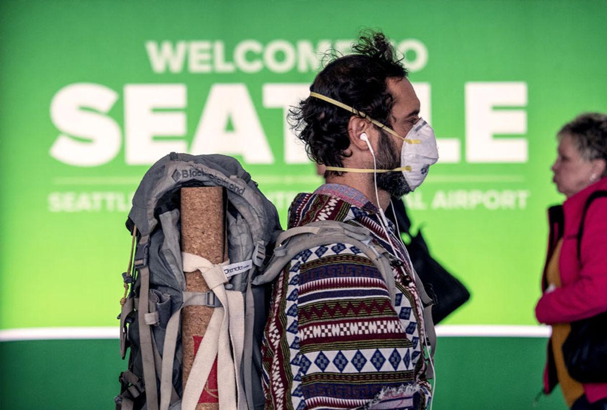 A passenger wearing a mask prepares to board a flight departing the Seattle-Tacoma International Airport (Getty Images)