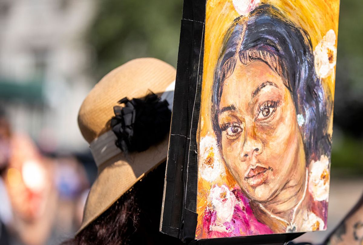 Artist Claudine Anrather wearing a mask holds her hand-painted sign tribute to Breonna Taylor in Union Square Park, New York (Ira L. Black/Corbis via Getty Images)