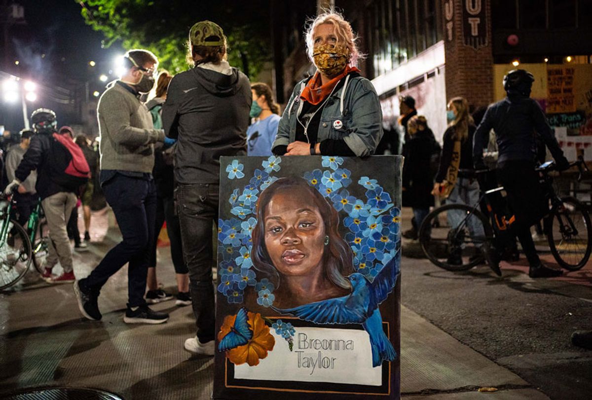 A demonstrator holds a painting of Breonna Taylor during a protest near the Seattle Police Departments East Precinct on June 7, 2020 in Seattle, Washington. Earlier in the evening, a suspect drove into the crowd of protesters and shot one person, which happened after a day of peaceful protests across the city. (David Ryder/Getty Images)