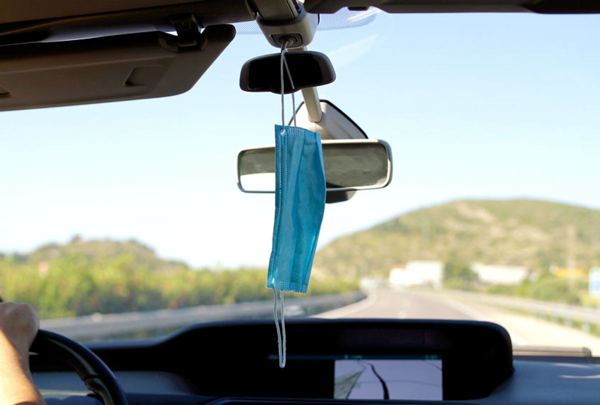 Protective mask hanging on a rearview mirror (Getty Images)