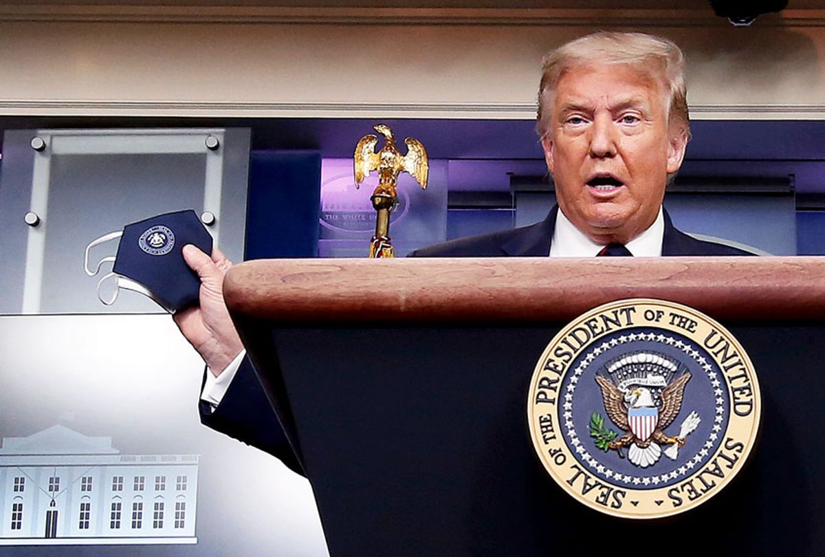 U.S. President Donald Trump talks to holds up his face mask during a press conference in the Brady Press Briefing Room at the White House July 21, 2020 in Washington, DC. Trump focused on his administration's handling of the global coronavirus pandemic. Poll numbers about his handling of COVID-19 have been falling as cases of deadly virus have spiked across the country. (Chip Somodevilla/Getty Images)