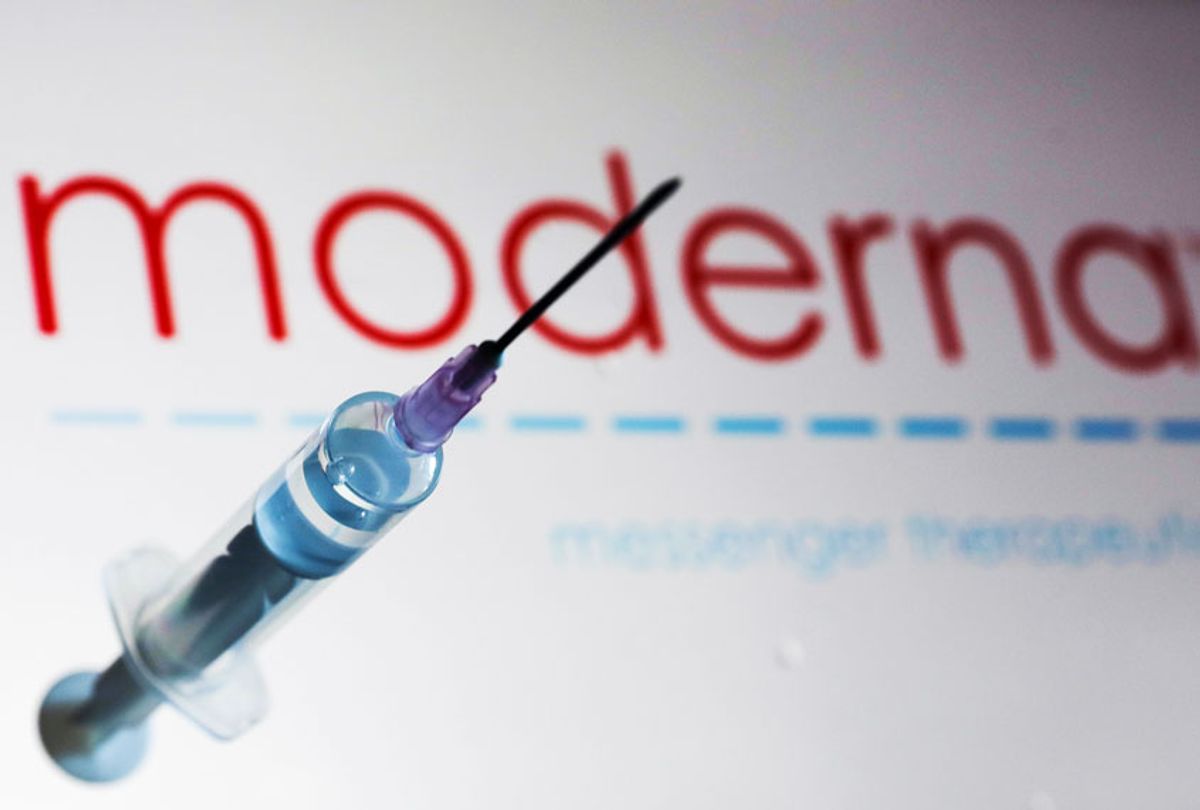 Medical syringe is seen with Moderna company logo displayed on a screen in the background (Photo Illustration by Jakub Porzycki/NurPhoto via Getty Images)