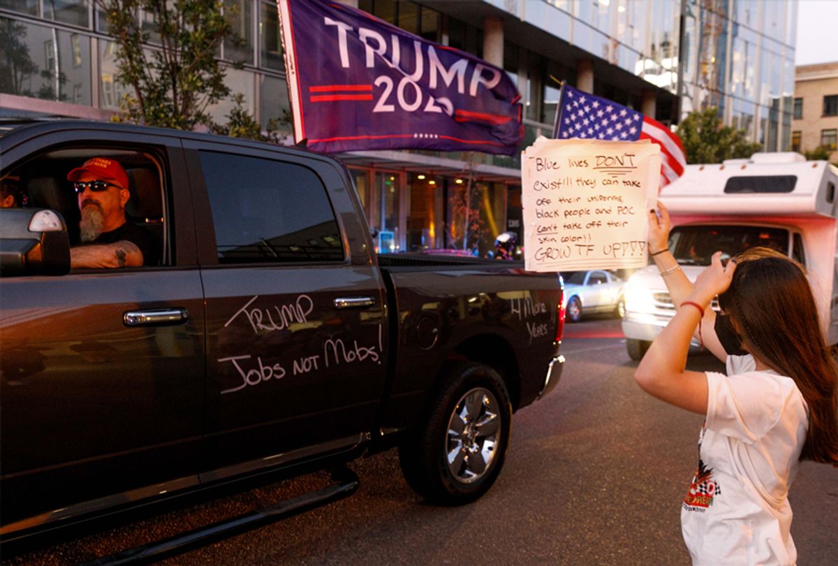 PORTLAND, OREGON, USA - AUGUST 29: A BLM protester block Pickup trucks and cars full of flag-waving Donald Trump supporters as they snarl traffic and parade through downtown Portland, Oregon on August 29, 2020. (Photo by John Rudoff/Anadolu Agency via Getty Images) (John Rudoff/Anadolu Agency via Getty Images)