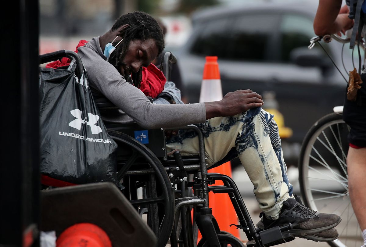 A man rests in a wheel chair outside a comfort station on Massachusetts Ave, in an area known as Methadone Mile, in Boston, MA on September 09, 2020. The area known as Methadone Mile has deteriorated over the past few months. Services are closed, and the homeless and those suffering from addiction have crowded the area. (Craig F. Walker/The Boston Globe via Getty Images)