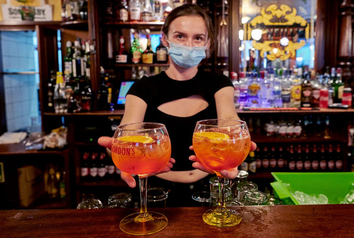 A staffer wearing a protective mask prepares cocktails for patrons at O'Neill's Irish Pub in Praça 5 de Outubro on August 23, 2020 in Cascais, Portugal. (Horacio Villalobos#Corbis/Corbis via Getty Images)