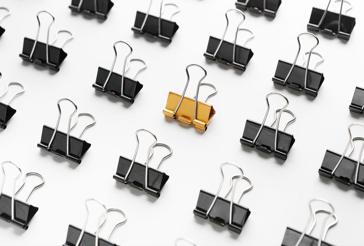 One yellow binder clip between black ones (Getty Images)