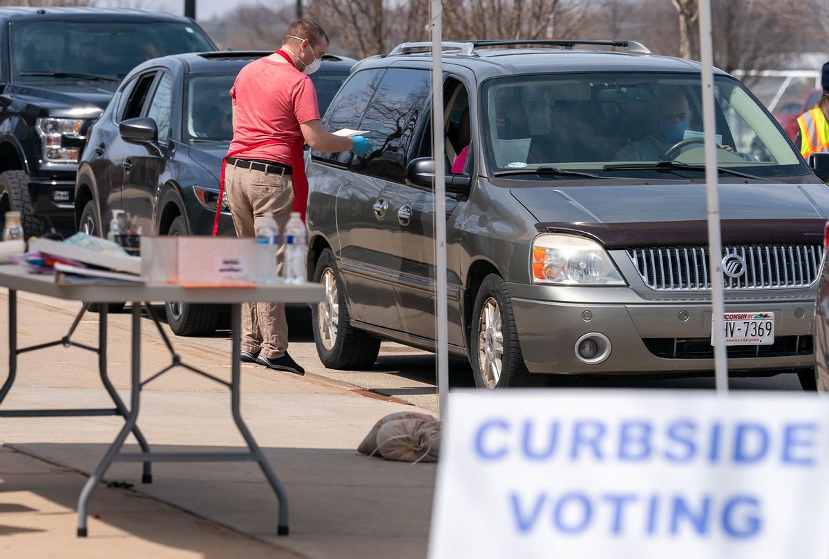 A poll worker talks to people during curbside voting on April 7, 2020 in Sun Prairie, Wisconsin. Residents in Wisconsin went to the polls a day after the U.S. Supreme Court voted against an extension of the absentee ballot deadline in the state. Because of the coronavirus, the number of polling places was drastically reduced. (Andy Manis/Getty Images)