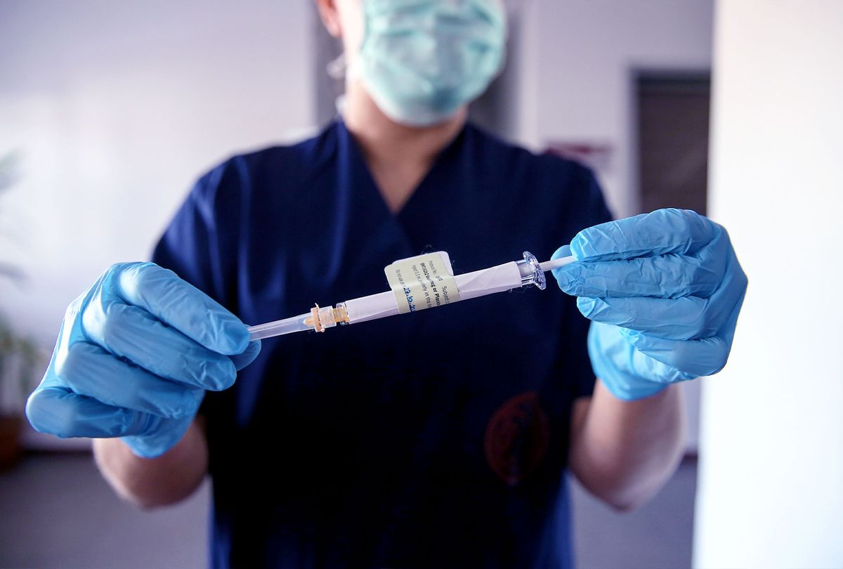 A health care worker holds an injection syringe of the phase 3 vaccine trial, developed against the novel coronavirus (COVID-19) pandemic by the U.S. Pfizer and German BioNTech company, at the Ankara University Ibni Sina Hospital in Ankara, Turkey on October 27, 2020. (Dogukan Keskinkilic/Anadolu Agency via Getty Images)