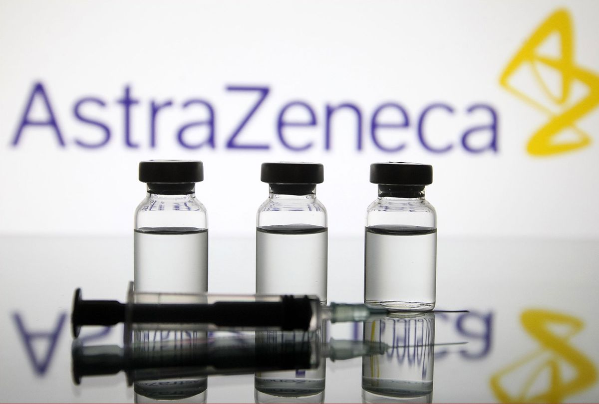 A medical syringe and vials in front of the AstraZeneca British biopharmaceutical company logo are seen in this creative photo taken on 18 November 2020. (STR/NurPhoto via Getty Images)