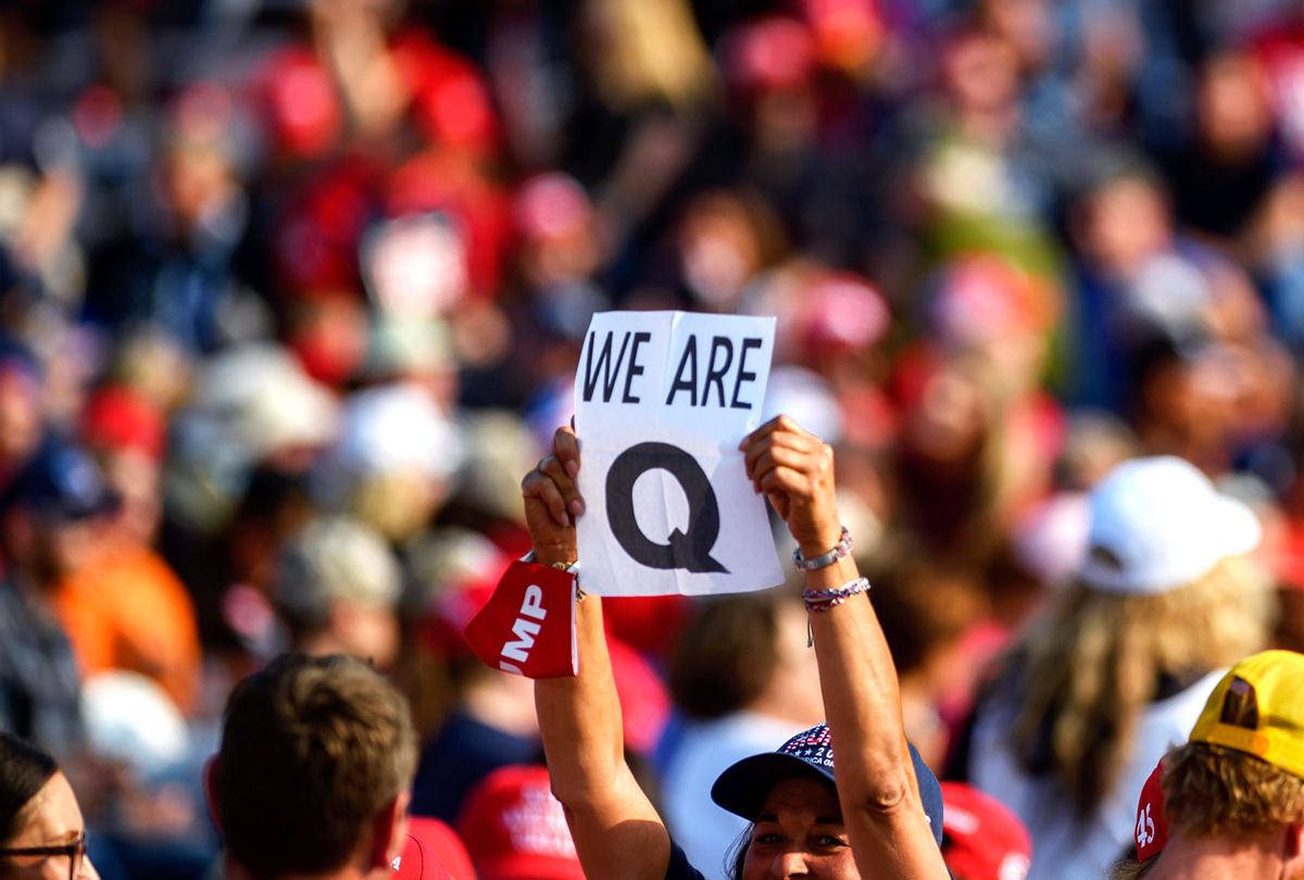 A woman holds up a QAnon sign to the media as attendees wait for President Donald Trump to speak at a campaign rally at Atlantic Aviation on September 22, 2020 in Moon Township, Pennsylvania. Trump won Pennsylvania by less than a percentage point in 2016 and is currently in a tight race with Democratic nominee, former Vice President Joe Biden. (Jeff Swensen/Getty Images)