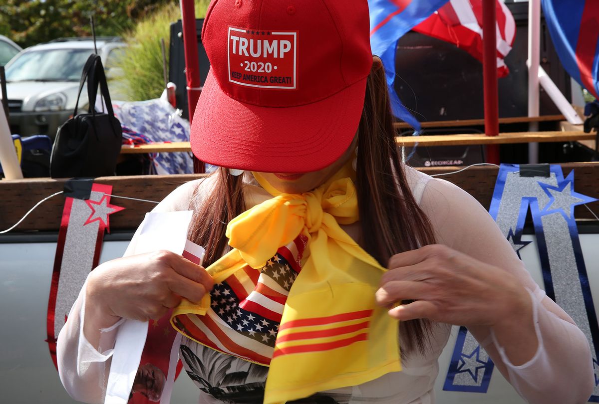 Holly Tran, who was born in Vietnam but now lives in Everett, Washington afixes her scarf bearing the flag colors from the United States and Vietnam prior to a rally supporting President Donald Trump on October 10, 2020 in Bellevue, Washington. The rally featured many state political and conservative speakers and advocated that wearing a mask should be optional. (Karen Ducey/Getty Images)