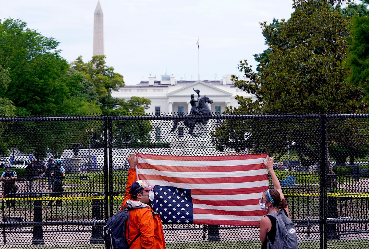 Demonstrators hold an upside down American flag against a tall fence at Lafayette Park near the White House while protesting against police brutality and the death of George Floyd, on June 2, 2020 in Washington, DC. Protests continue to be held in cities throughout the country over the death of George Floyd, a black man who was killed in police custody in Minneapolis on May 25. (Drew Angerer/Getty Images)