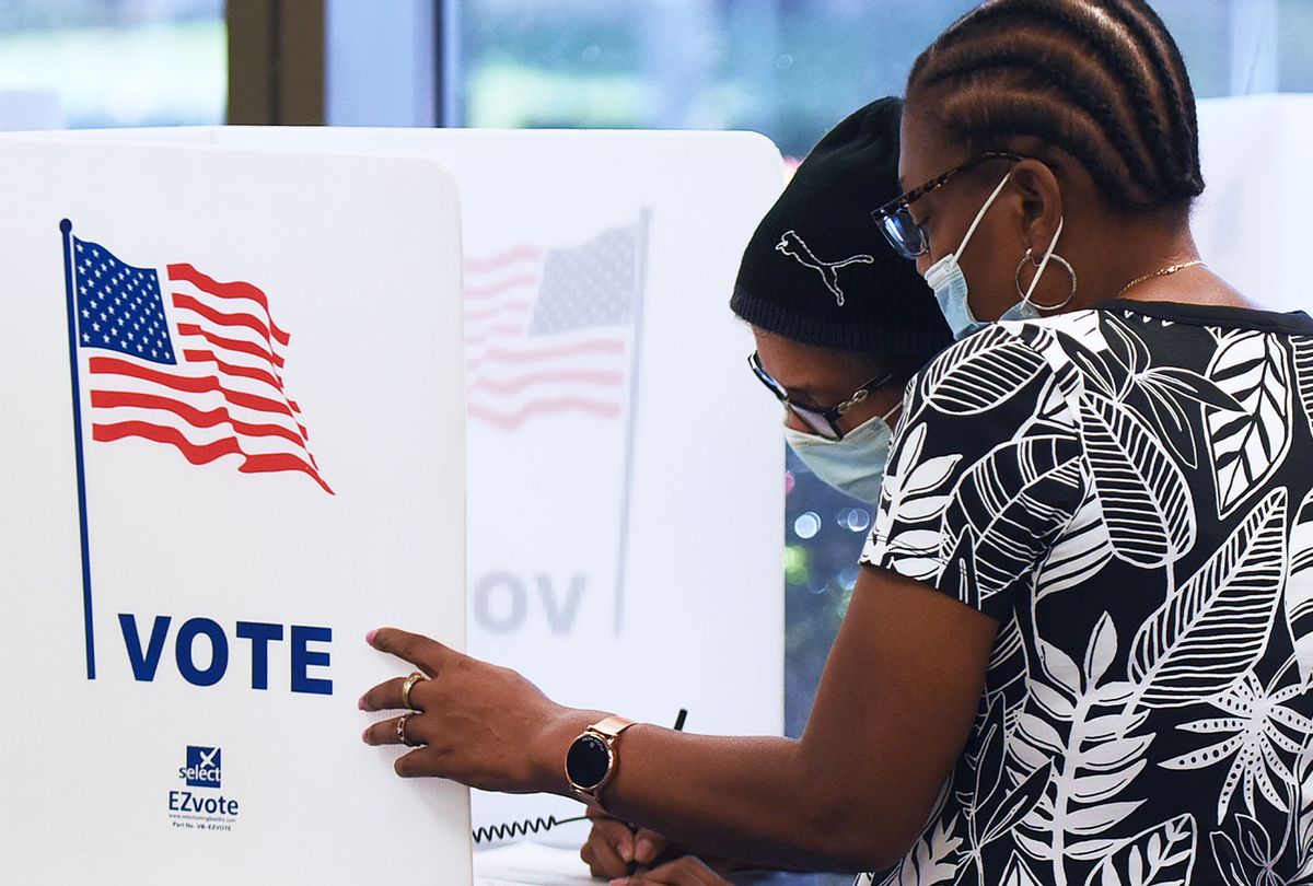 Women wearing face masks fill out vote-by-mail ballots at the Orange County Supervisor of Elections office on October 15, 2020 in Orlando, Florida.  (Paul Hennessy/NurPhoto via Getty Images)