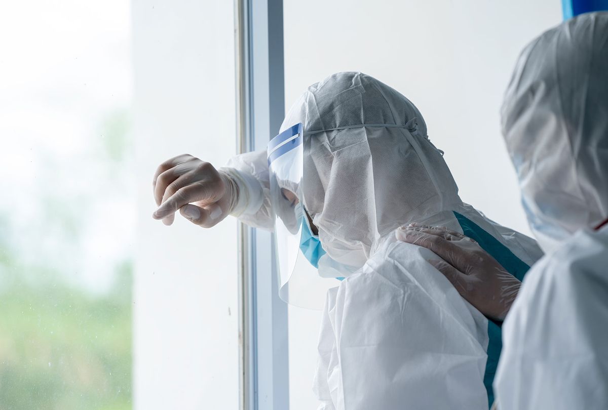 Distressed doctor wearing protective suit to fight coronavirus pandemic (Getty Images)
