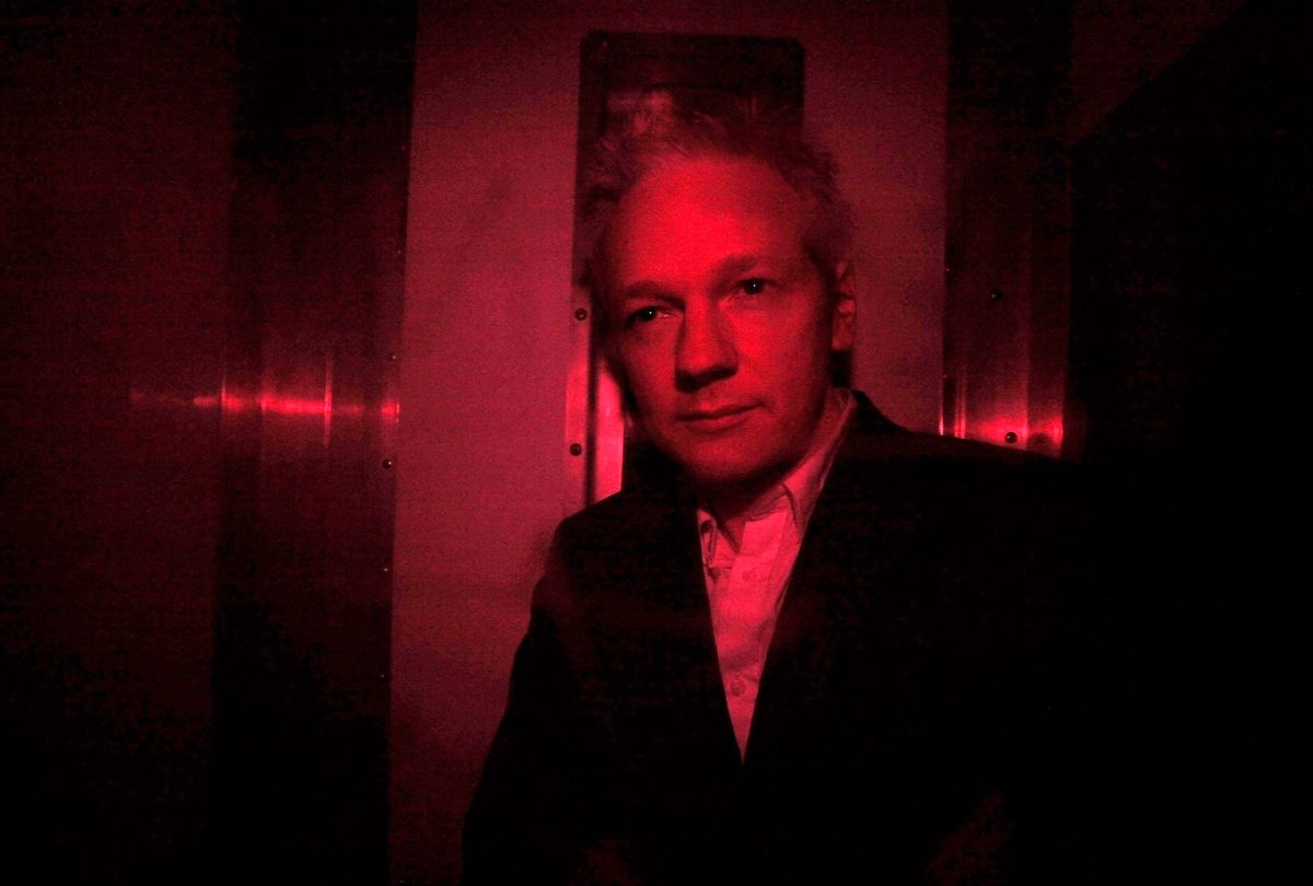 Wikileaks founder Julian Assange looks out from inside a prison van with red windows as he arrives at the Royal Courts of Justice on December 16, 2010 in London, England. (Oli Scarff/Getty Images)