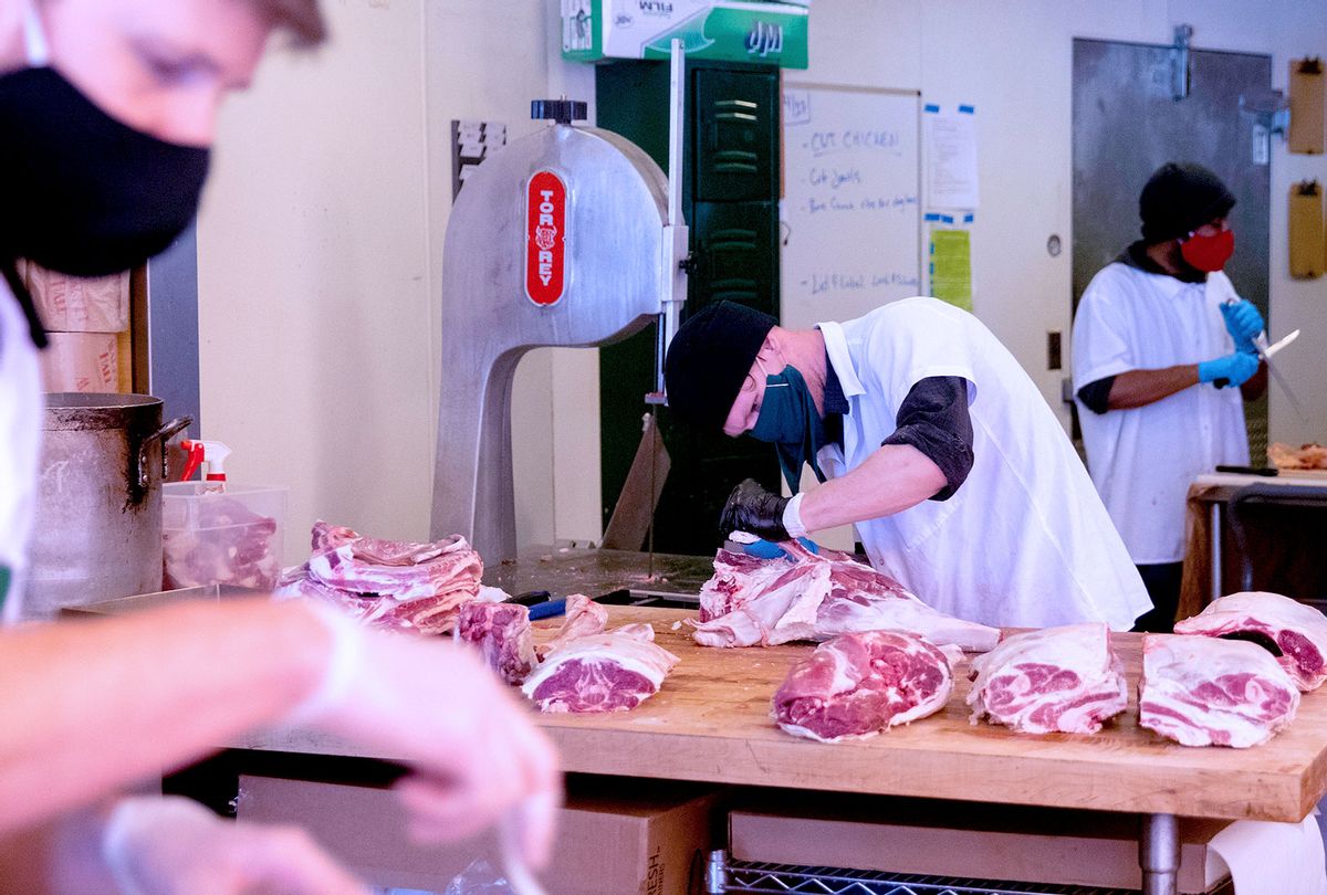 A butcher wears a mask and gloves as he works to deconstruct a lamb while at Marin Sun Farms Butcher Shop in Oakland, Calif. Wednesday, April 29, 2020. (Jessica Christian/The San Francisco Chronicle via Getty Images)