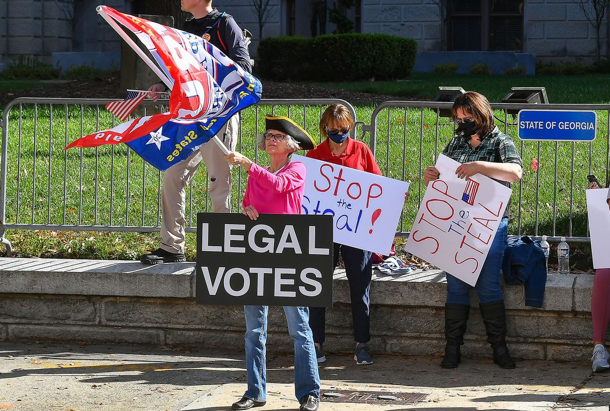 A supporter of President Trump holds a sign and waves a flag at a Stop The Steal rally in front of the Georgia State Capitol Building on November 28th, 2020 in Atlanta, GA. (Rich von Biberstein/Icon Sportswire)