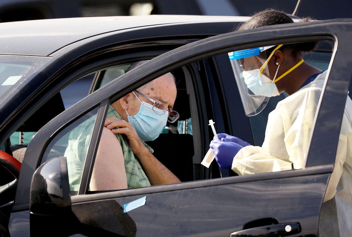 Staff and volunteers distribute the COVID-19 vaccine to people as they remain in their vehicles at The Forum in Inglewood Tuesday. The Forum is one of five mass-vaccination sites that opened Tuesday in Los Angeles county. (Al Seib / Los Angeles Times via Getty Images)