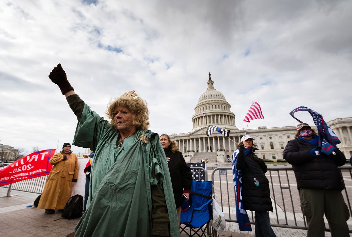 A protester dressed like the Statue of Liberty stands with a fist raised on the grounds of the Capitol Building on January 6, 2021 in Washington, DC. A pro-Trump mob stormed the Capitol earlier, breaking windows and clashing with police officers. Trump supporters gathered in the nation's capital to protest the ratification of President-elect Joe Biden's Electoral College victory over President Donald Trump in the 2020 election. (Jon Cherry/Getty Images)