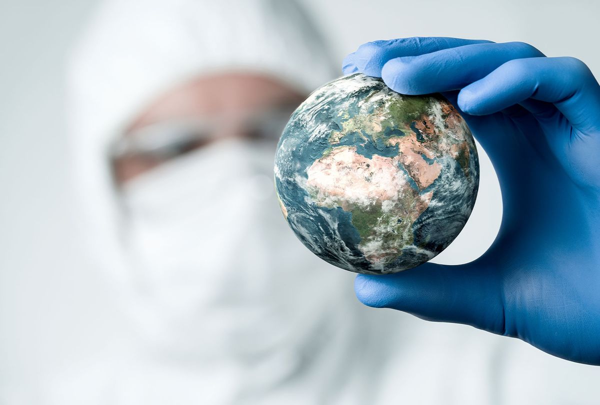 Close up of scientist holding and analyzing planet earth (Getty Images)