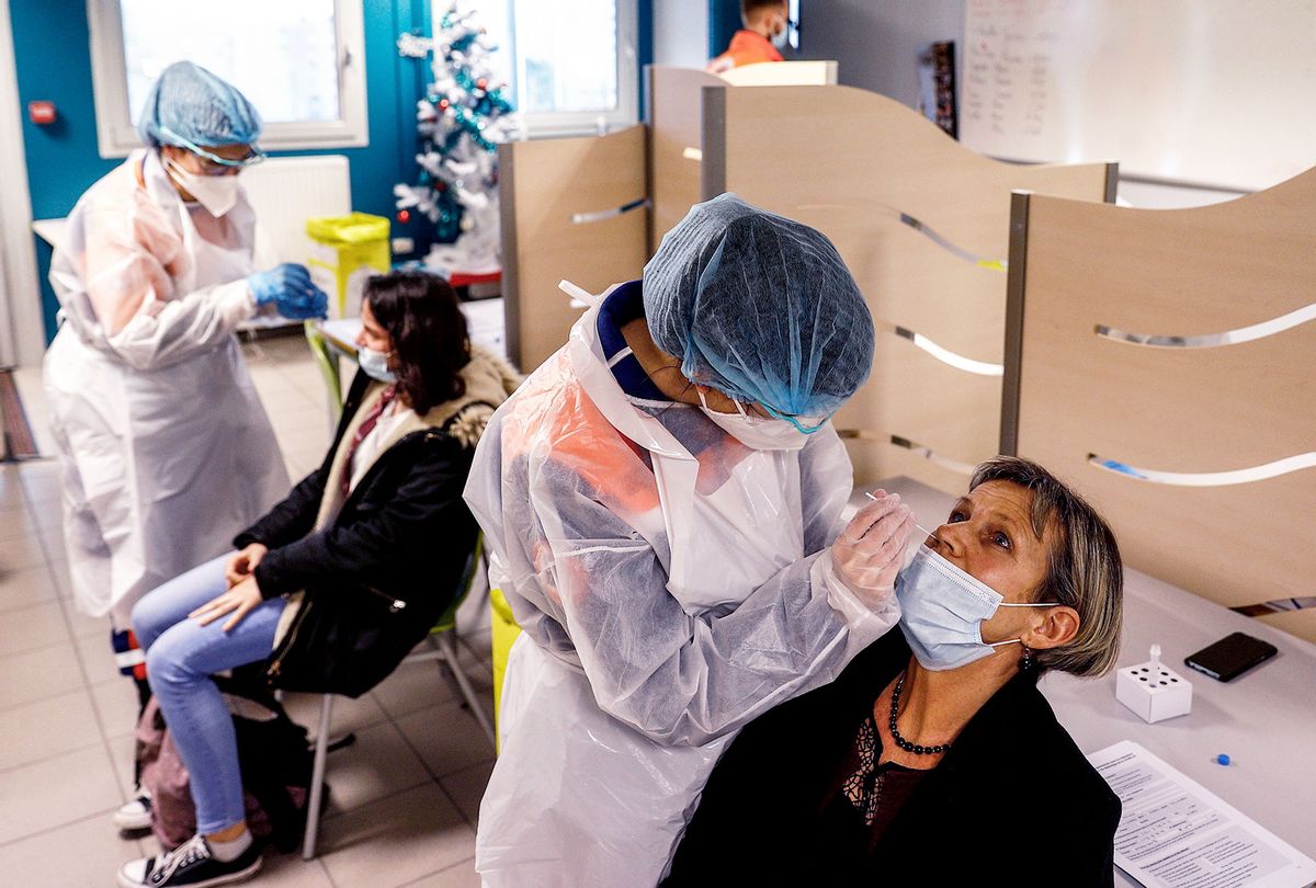A member of the Civil Protection takes a nasal sample with a swab from a teacher at an operation center for a Covid-19 mass testing campaign at a High School in Montivillliers, northern France on December 15, 2020. (SAMEER AL-DOUMY/AFP via Getty Image)