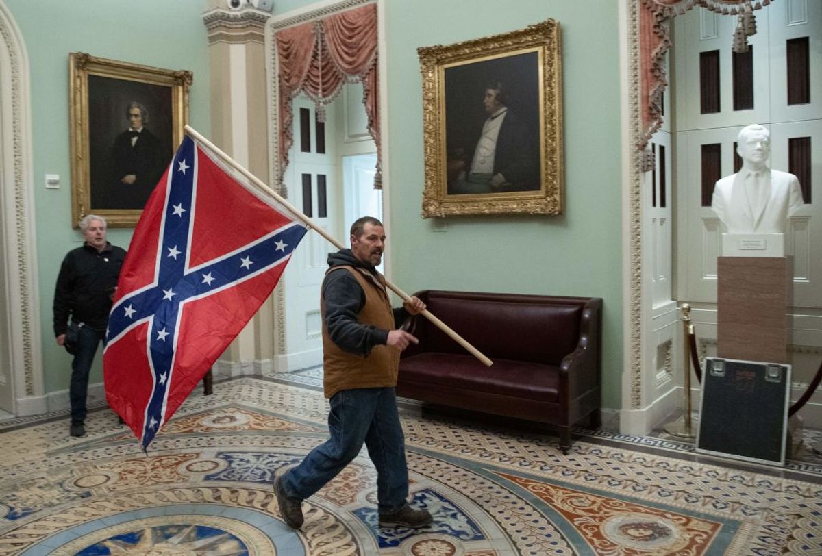 A supporter of President Trump carries a Confederate flag in the U.S. Capitol Rotunda on Jan. 6, 2021. (SAUL LOEB/AFP via Getty Images)