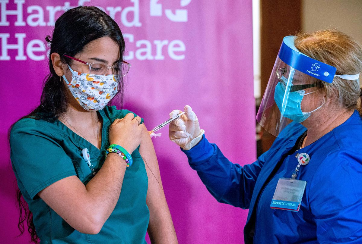 Medical worker Jasmine Ortiz is given the the second dose of the Pfizer/BioNTech vaccine twenty-one days after receiving the first shot from RN Valerie Massaro of Hartford HealthCare, at the Hartford Convention Center in Hartford, Connecticut on January 4, 2021. (JOSEPH PREZIOSO/AFP via Getty Images)