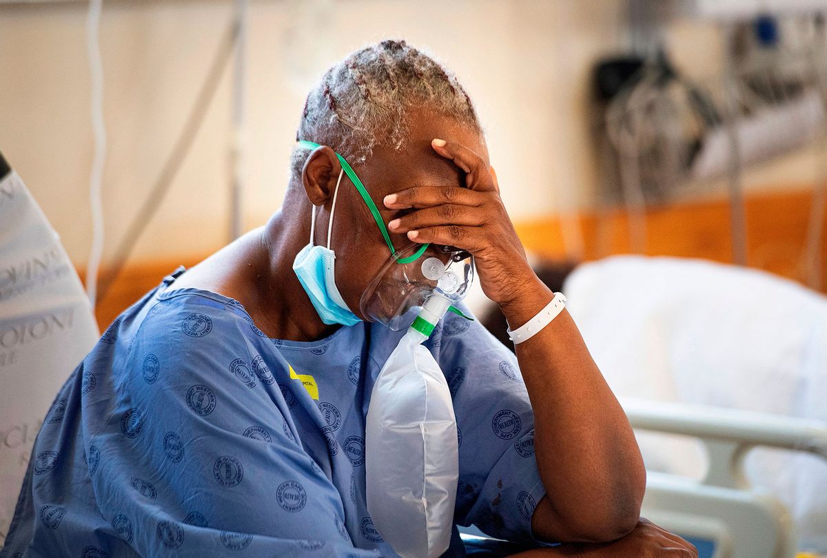 A patient with the COVID-19 breaths in oxygen in the COVID-19 ward at Khayelitsha Hospital, about 35km from the centre of Cape Town, on December 29, 2020. (RODGER BOSCH/AFP via Getty Images)