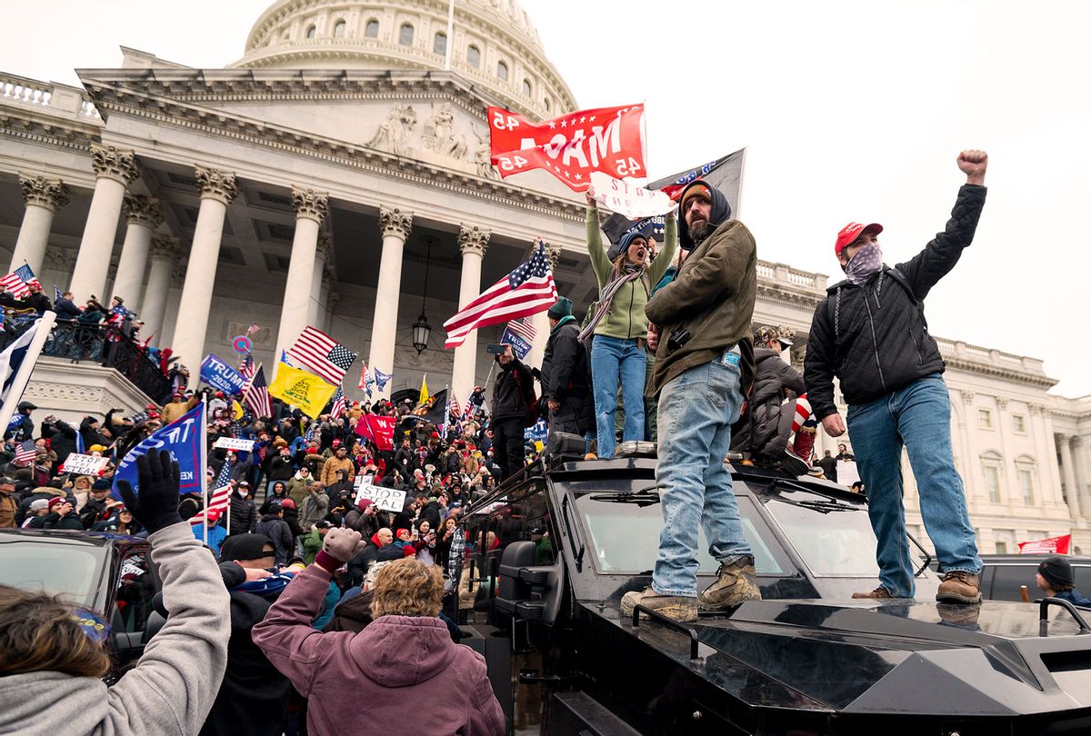Trump supporters stand on the U.S. Capitol Police armored vehicle as others take over the steps of the Capitol on Wednesday, Jan. 6, 2021, as the Congress works to certify the electoral college votes. (Bill Clark/CQ-Roll Call, Inc via Getty Images)
