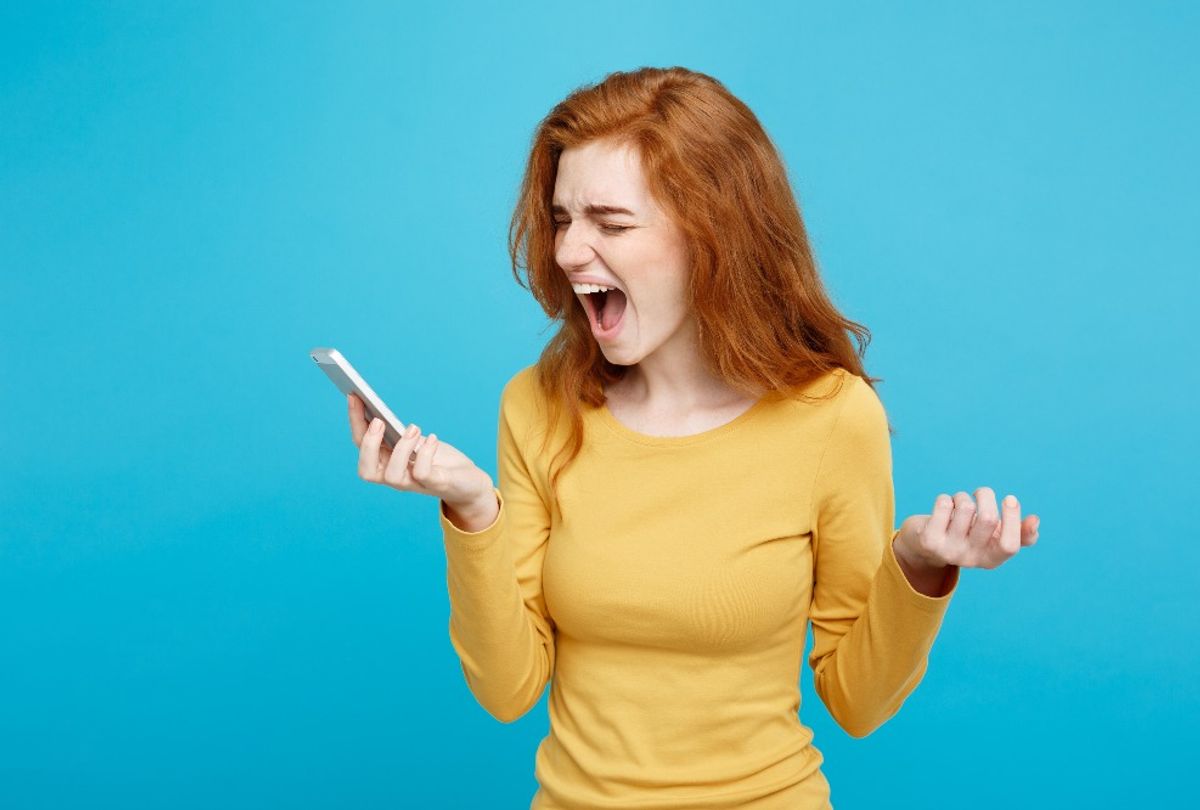 A woman screams into her phone (Getty stock photo)
