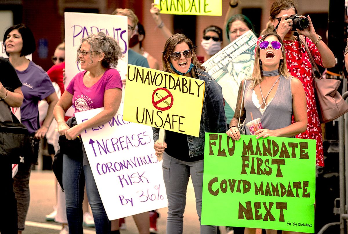 Anti-vaccine activists hold signs and chant in front of the Massachusetts State House against Governor Charlie Baker's mandate that all Massachusetts school students enrolled in child care, pre-school, K-12, and post-secondary institutions must receive the flu vaccine this year on August 30, 2020 in Boston, Massachusetts. (Scott Eisen/Getty Images)