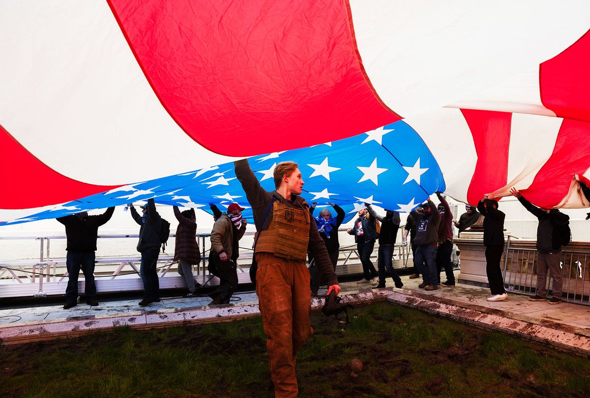 A group of pro-Trump protesters raise a giant America Flag on the West grounds of the Capitol Building on January 6, 2021 in Washington, DC. (Jon Cherry/Getty Images)