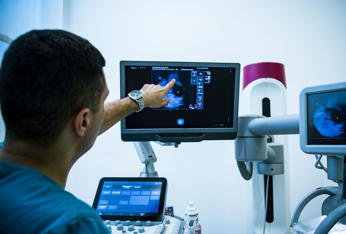 Doctor examining breasts with mammogram (Getty Images)