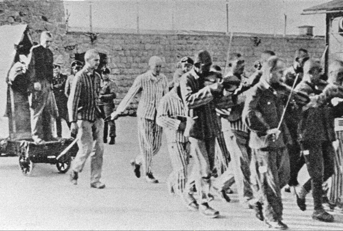 Prisoners are forced to give company to fellow sufferers with happy music to execution at Mauthausen concentration camp in Austria (Votava/Imagno/Getty Images)