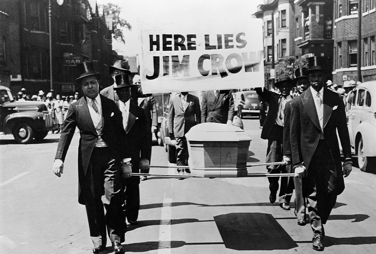 African-American men wearing tuxedos carry a coffin and a "Here Lies Jim Crow" sign down the middle of a street as a demonstration against "Jim Crow" segregation laws. 1944. (CORBIS/Corbis via Getty Images)