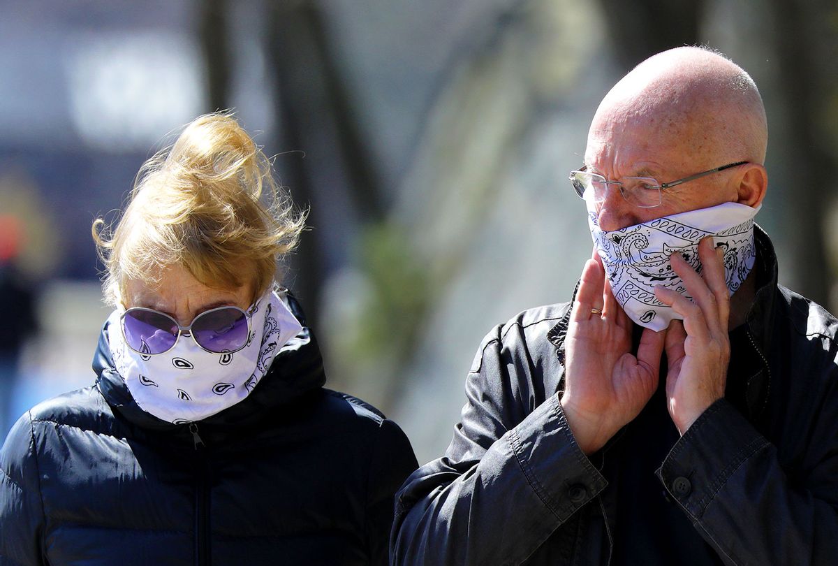 Couple wearing bandanas as they walk around the Chestnut Hill Reservoir in Boston on Apr. 6, 2020 (Getty Images)
