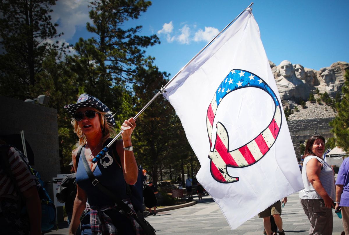 A Donald Trump supporter holding a QAnon flag (Scott Olson/Getty Images)