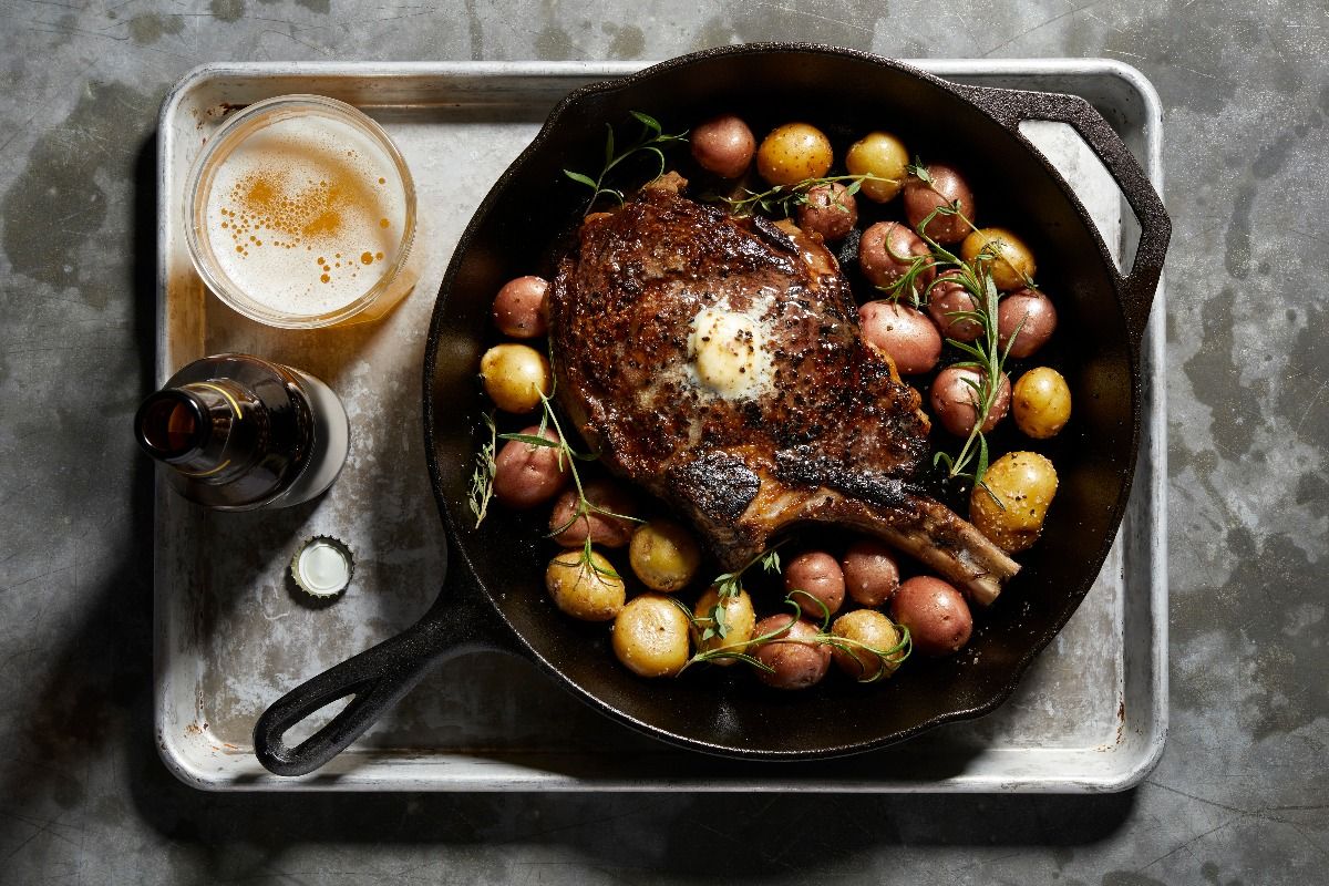 Skillet with large tomahawk steak and potatoes. (Getty Images)
