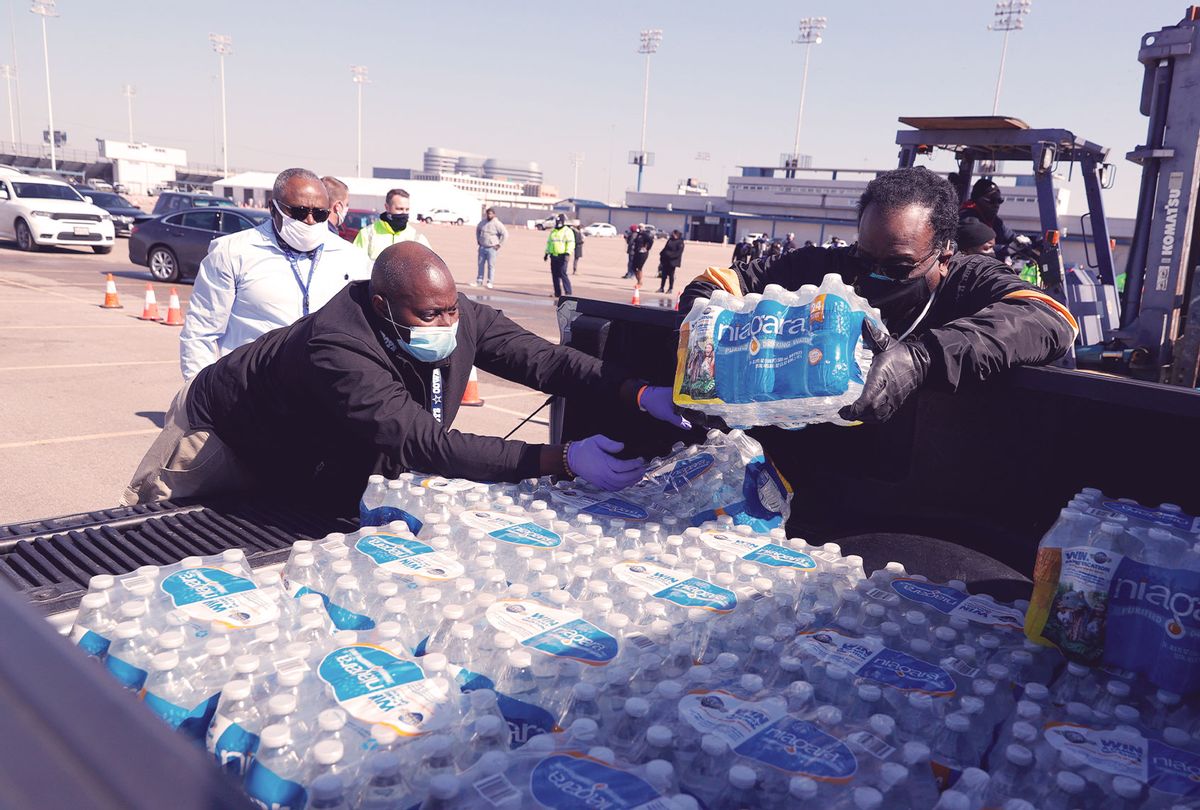 Volunteers load cases of water into the bed of a truck during a mass water distribution at Delmar Stadium on February 19, 2021 in Houston, Texas. Much of Texas is still struggling with historic cold weather, power outages and a shortage of potable water after winter storm Uri swept across 26 states with a mix of freezing temperatures and precipitation. Many Houston residents do not have drinkable water at their homes and are relying on city water giveaways. (Justin Sullivan/Getty Images)