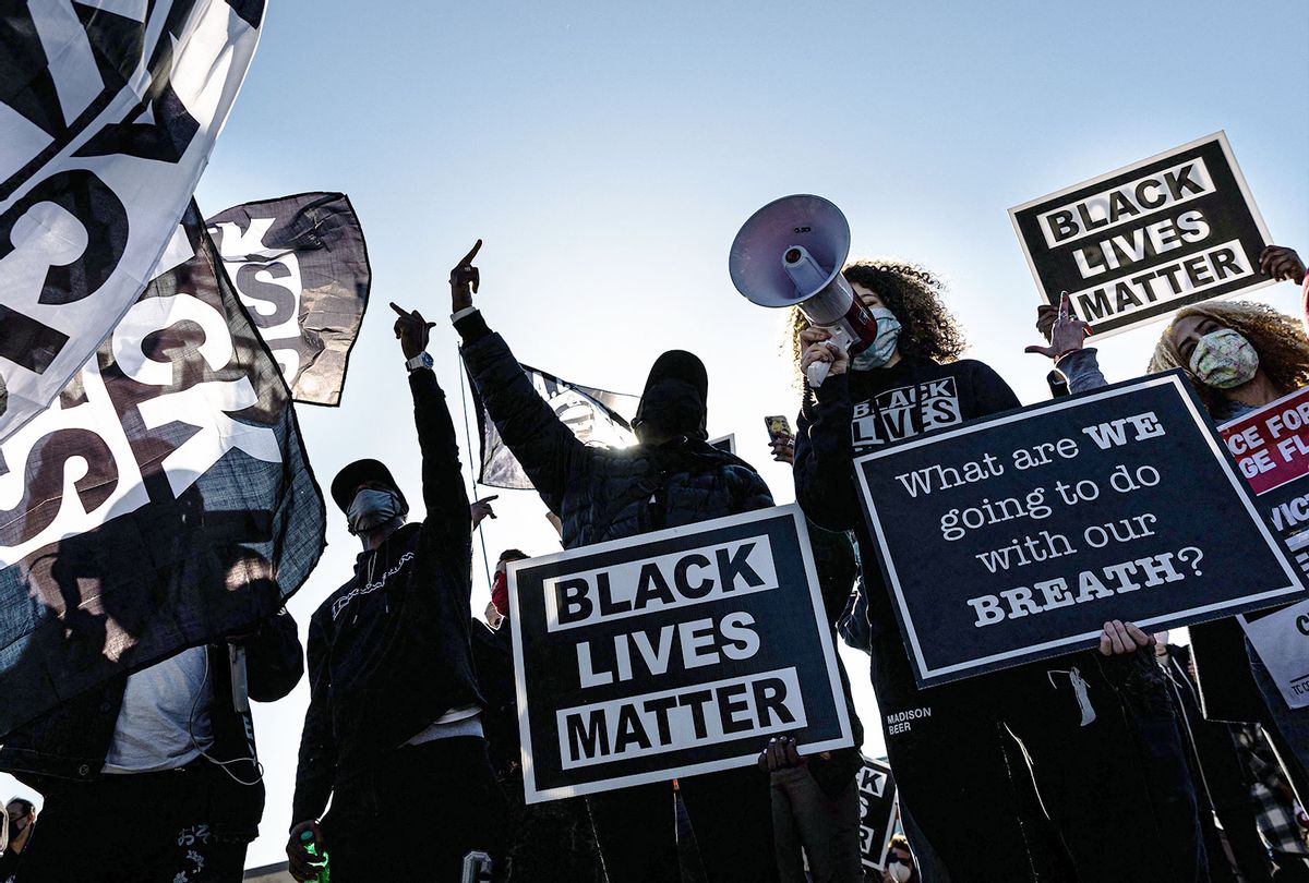 Demonstrators hold "Black Lives Matter" signs as they participate in the "Justice for George Floyd" march outside the Minnesota State Capitol on March 19, 2021 in Saint Paul, Minnesota. (KEREM YUCEL/AFP via Getty Images)