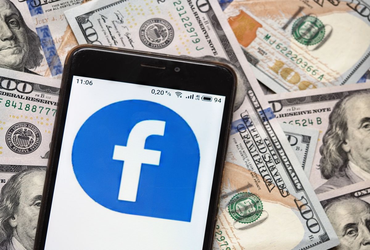 Facebook logo seen displayed on a smartphone with 100 dollar bills in the background. (Photo Illustration by Igor Golovniov/SOPA Images/LightRocket via Getty Images)